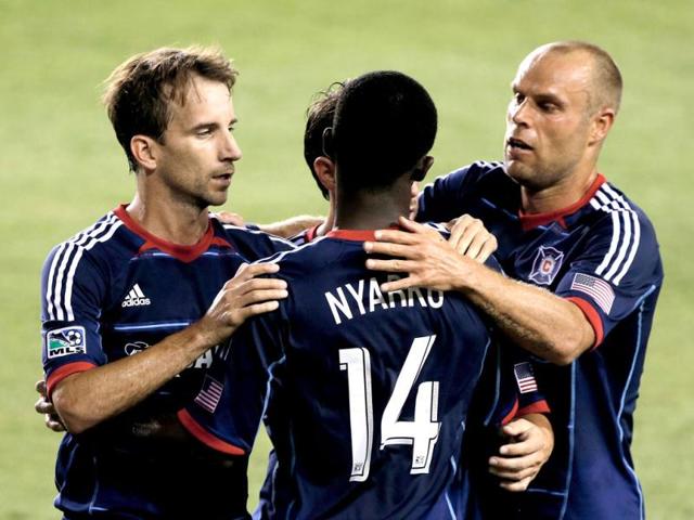 Mike Magee #9 (L) and Patrick Nyarko #14 (C) and Joel Larentowicz #26 (R) of the Chicago Fire celebrate after Magee scored a second half goal against the Houston Dynamo at BBVA Compass Stadium in Houston, Texas. (AFP Photo)
