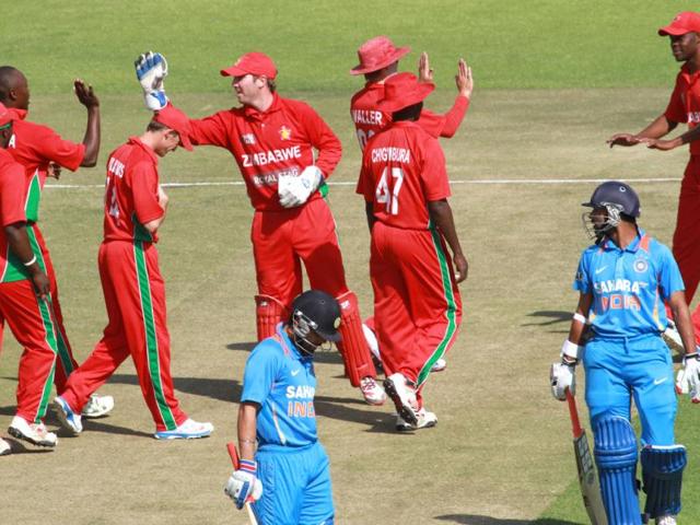 Zimbabwean players celebrate the wicket of India's Rohit Sharma (R) during their third ODI, in Harare. (AP Photo)