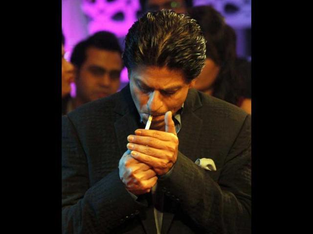 Shah Rukh Khan was even caught lighting a cigarette while promoting his Chennai Express in Mumbai. (AP Photo) (HT does not promote smoking cigarettes.)