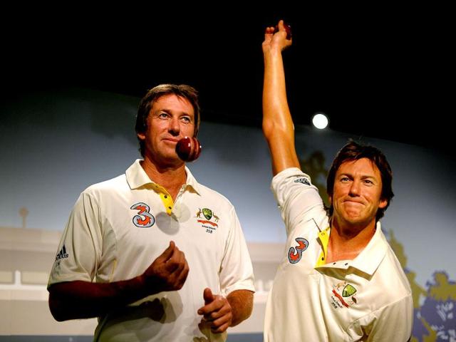 Australia's cricket legend Glenn McGrath (L) tosses a ball as he poses for photos during the launch of his wax figure at Madame Tussauds in Sydney. (AFP Photo)
