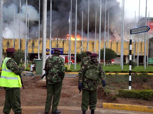 Policemen watch the fire rage at the international arrivals unit of Jomo Kenyatta International Airport, Nairobi, Kenya. (AP Photo)