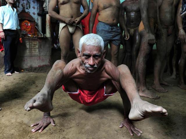 Wrestler Ram Gopal performs during a bout of traditional wrestling at the Loknath Vyayamsala on the occasion of Nag Panchami, in Allahabad. (AFP Photo)