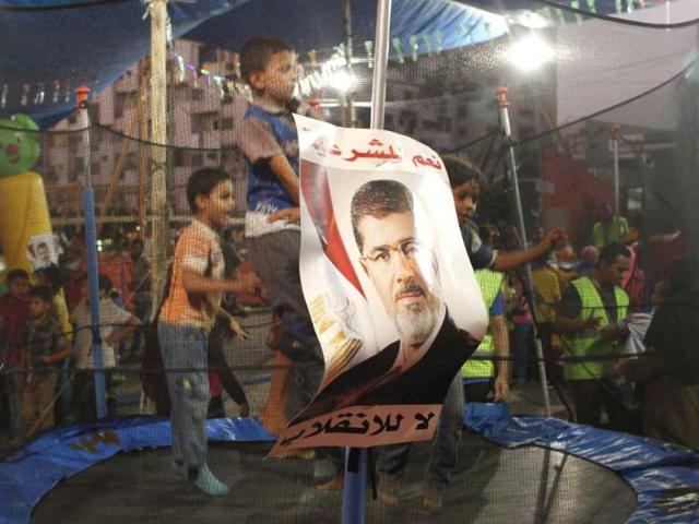 Children of the supporters of deposed Egyptian President Mohamed Morsi jump on a trampoline in a makeshift funfair that was setup outside of the sit-in area of Rab'a al- Adawiya Square, where they are camping, in Cairo. REUTERS