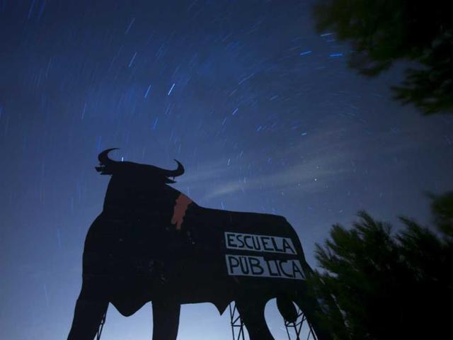 Stars seen as streaks from a long camera exposure are seen behind and above a roadside silhouette of a Spanish fighting bull, conceived decades ago as highway billboards, in Villarejo de Salvanes, central Spain, 2013. A sign on the bull, put up by protesters, reads "State schools" as a reference for a demand for the state funded schools to continue. AP Photo