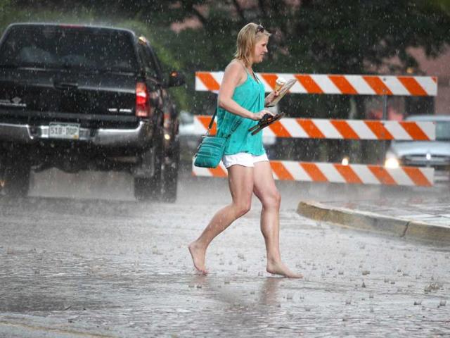 A woman runs for cover in the rain after fire trucks broadcasted a flash flood warning, three days after a deadly flash flood struck the same location, in Manitou Springs, Colorado. (AP Photo)