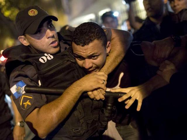 A man is detained by police officers during a protest against the governor of Rio de Janeiro state, Sergio Cabral. (AP Photo)