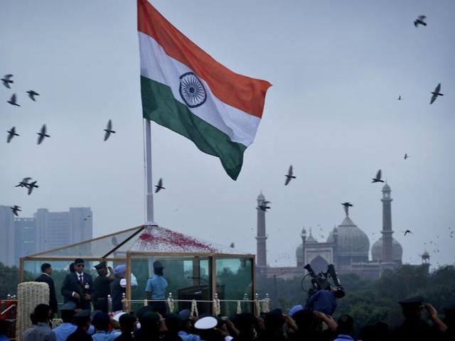 Indian Prime Minister Manmohan Singh, center, unfurls the Indian tricolor from the ramparts of Red Fort to celebrate Independence Day, in New Delhi. (AP Photo)