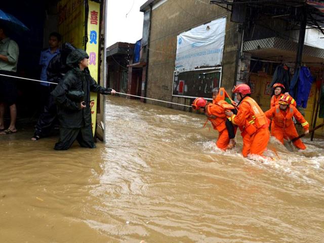 Rescuers carry a woman across a flooded street after Typhoon Utor hit Jiangyong county, Hunan province. (Reuters Photo)