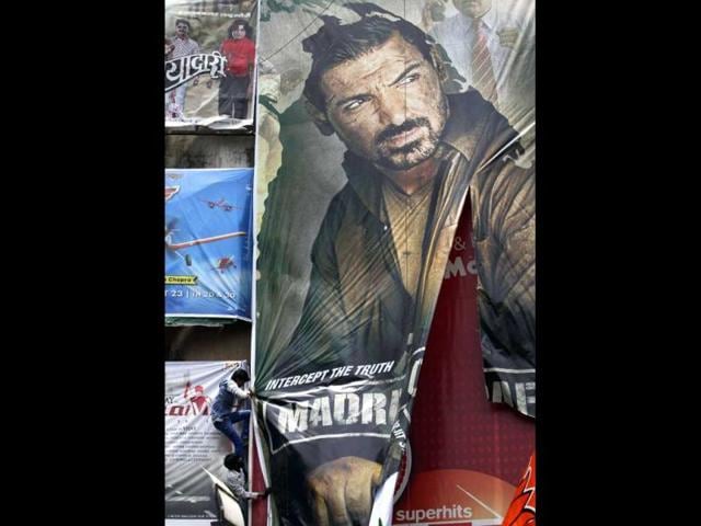 Protestors tear down a poster of Madras Cafe that features actor John Abraham outside a cinema hall in Mumbai. (AP Photo)