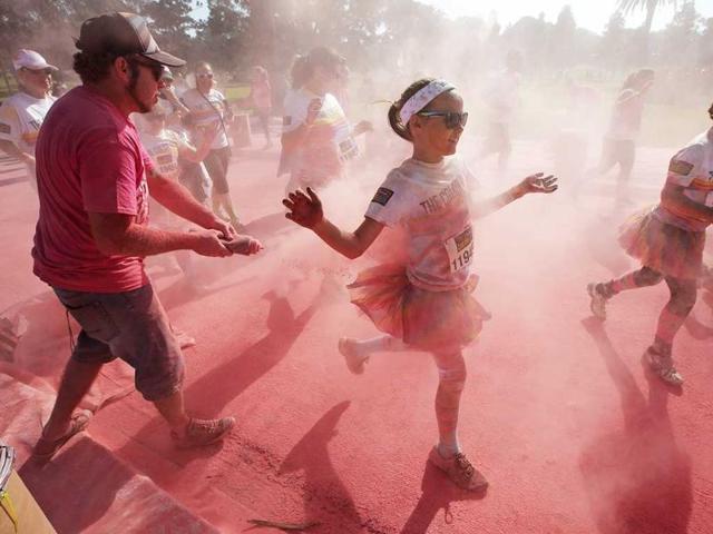 Color powder is squirted onto participants in The Color Run in Sydney, Australia. About 3,000 kilograms of colored corn starch is flung at the 15,000 runners over the 5 km course through Centennial Park. (AP Photo)