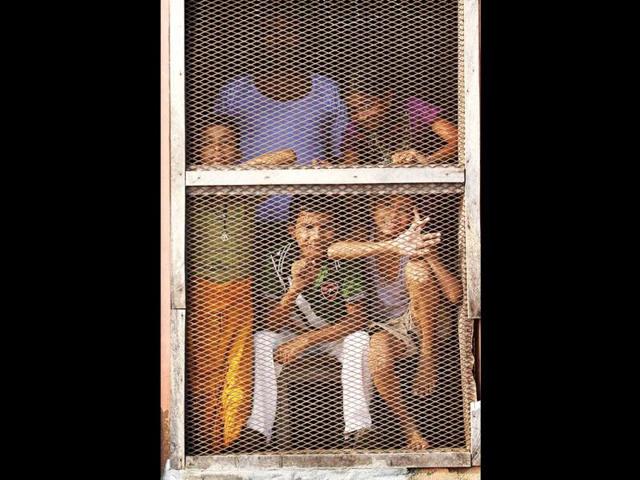 People watch from the window of their house as activists of the Vishwa Hindu Parishad (VHP) scuffle with policemen before getting detained at Ayodhya. Policemen detained more than 500 VHP activists as they tried to take out religious procession, which aims at expediting the movement for construction of the Ram Temple in Ayodhya. (AP Photo)