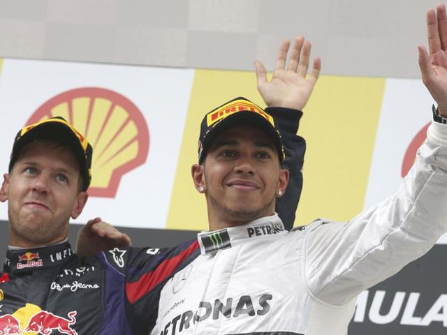 Winner Sebastian Vettel of Germany (L) celebrates on the podium with third placed Lewis Hamilton after the Belgium Grand Prix at the Spa-Francorchamps circuit. (AP Photo)