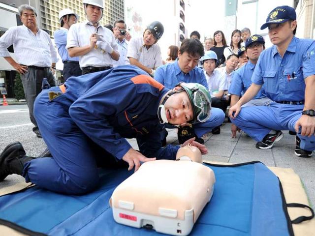 People learn CPR from a rescue worker during a disaster drill at Ginza shopping district in Tokyo. (AFP Photo)