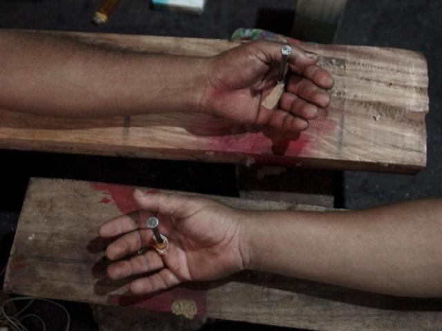Hands of two bus drivers nailed to wooden crosses during a protest by bus drivers in the outskirts of Asuncion, Paraguayan. (Reuters Photo)