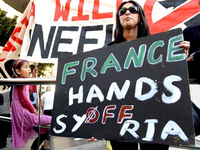 A woman holds a placard during a protest against a possible US military strike against Syria, in Sydney. AFP photo