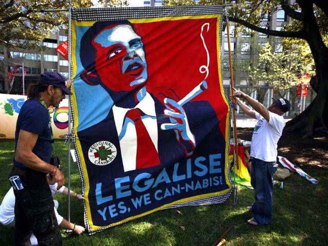 Members of a group in Sydney lift a banner displaying a parody of US President Barack Obama's election campaign poster. (Reuters Photo)