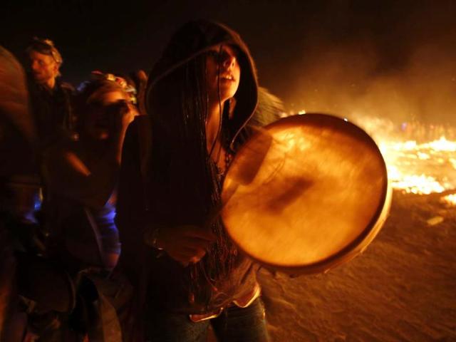 A participant makes her way around the flames at the Burning Man 2013 arts and music festival in the Black Rock Desert of Nevada (Reuters Photo)