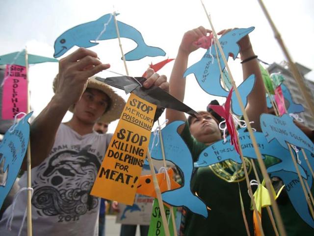 Protesters place paper dolphins on sticks outside the Japanese Embassy in Manila, Philippines. (AP Photo)