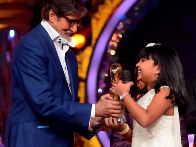 Amitabh Bachchan hands over the winner's trophy to Anjana Padmanabhan who's the first winner of the singing reality show Indian Idol Junior.