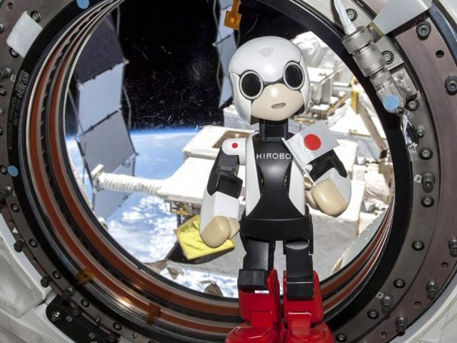 Humanoid communication robot Kirobo holds a Japanese national flag as it speaks a message, during a session to check the success of its first conveyance into space, at the International Space Station. (Reuters Photo)