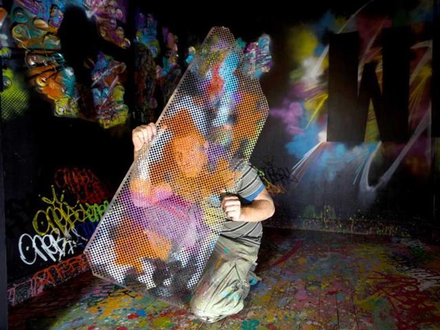 French artist Nebay posing in a flat he decorated in a building set for demolition in 2014, where artists from all over the world occupy the 36 flats to create "street art works". (AFP Photo)