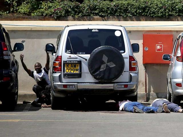 People come out from hiding under a car next to bodies in a car park as police search for gunmen in Westgate shopping centre in Nairobi, Kenya. (Reuters Photo)