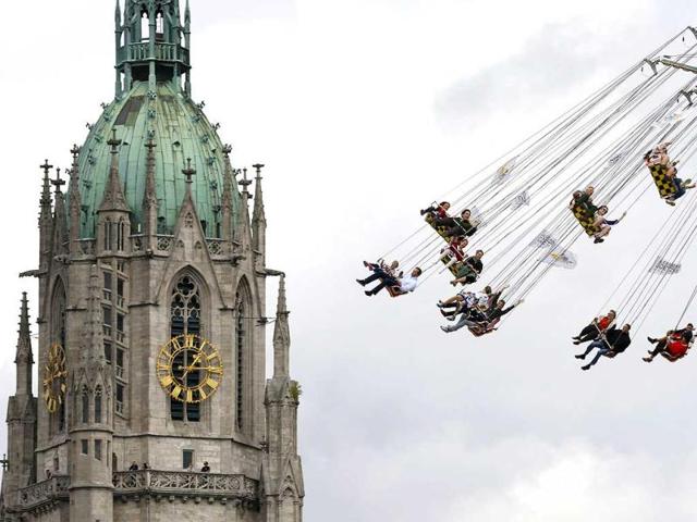 Visitors enjoy a fairground ride in front of St. Pauls Church during the opening day at 180th Oktoberfest in Munich. Reuters photo