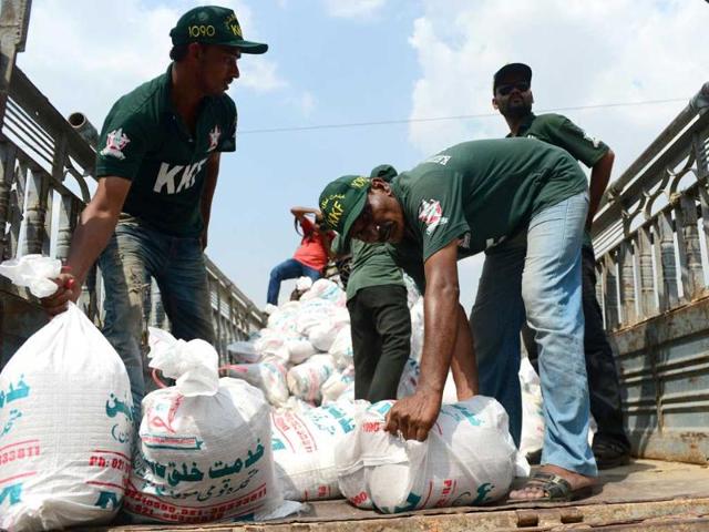 Members of the Pakistani Muttahida Qaumi Movement (MQM) load earthquake relief supplies onto a truck in Karachi. (AFP Photo)