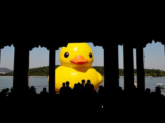 Visitors look at an 18-metre tall inflatable duck after its move to Lake Kunming at the historic Summer Palace in Beijing. (AFP photo)