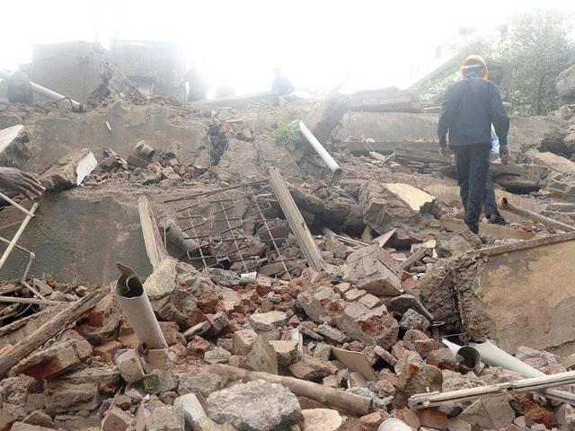 Firefighters and rescue workers are seen searching for survivors at the site of the collapsed building in Mumbai (AFP Photo)