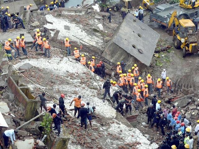 Firefighters and rescue workers are seen searching for survivors at the site of the collapsed building in Mumbai. (AFP Photo)
