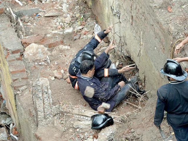 Firefighters and rescue workers are seen searching for survivors at the site of the collapsed BMC building in Dockyard Road in Mumbai. (AFP Photo)