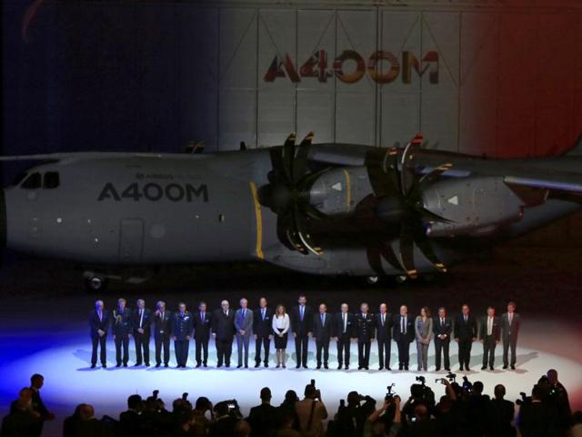 Spain's Crown Prince Felipe (C) poses for a family photo next to an Airbus A400M military transport plane during a ceremony at an assembly plant in the Andalusian capital of Seville. (Reuters Photo)