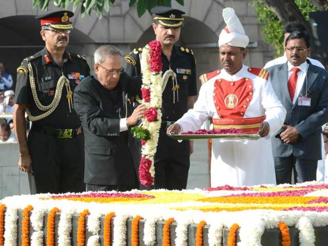 President Pranab Mukherjee (C) pays his respects at the memorial to the Father of the Nation Mahatma Gandhi at Rajghat in New Delhi on 144th birth anniversary. (AFP Photo)