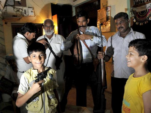 Guns are a matter of pride and not just protection in Uttar Pradesh. In this picture, a family in a village near Etah flaunt rifles and revolvers at their home. Children get a chance to hold weapons too. (Vipin Kumar/ HT photo)