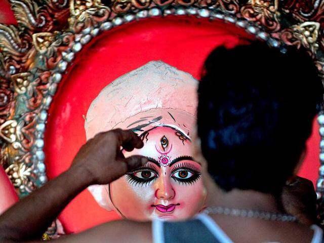 An artisan gives the final touches to an idol of goddess Durga ahead of the Durga Puja festival at a workshop in Allahabad. (AFP Photo)