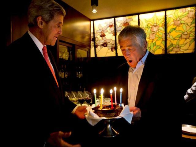 US secretary of defence Chuck Hagel blows out the candles on a surprise birthday cake from US secretary of state John Kerry in Tokyo.(Reuters photo)