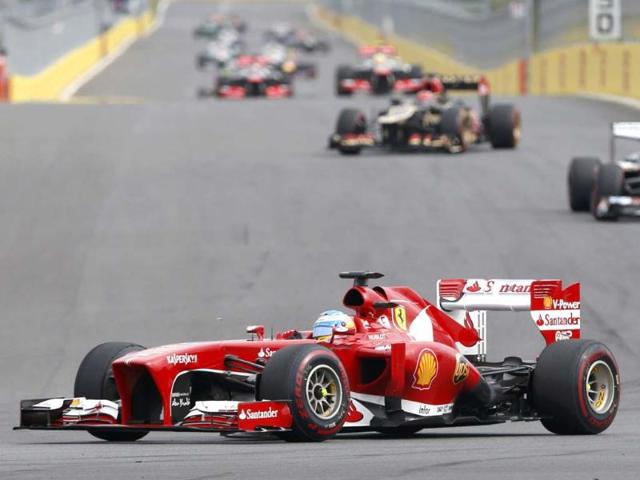 Ferrari-driver-Fernando-Alonso-of-Spain-centre-and-Ferrari-driver-Felipe-Massa-of-Brazil-3rd-right-walk-past-grid-girls-during-a-drivers-track-parade-ahead-of-the-start-of-the-Formula-One-Korean-Grand-Prix-in-Yeongam-AFP-Photo