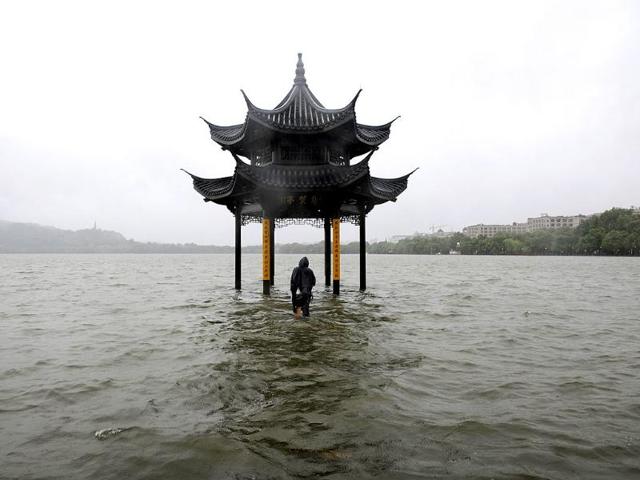 A man walks towards a flooded pavilion by the overflowing West Lake after Typhoon Fitow hit Hangzhou in eastern China. (Reuters Photo)