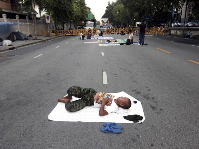An anti-government protester sleeps outside Government House in Bangkok. (Reuters Photo)