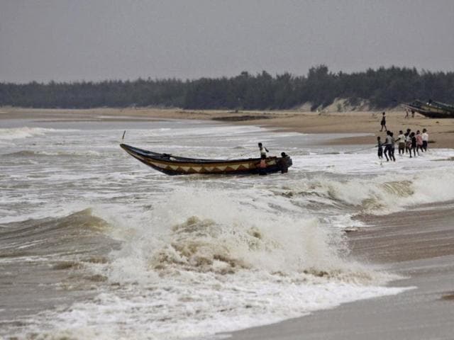 Fishermen pull out a country boat from the Bay of Bengal at Gokhurkuda in Ganjam district, Odisha following a cyclone alert. (AP photo)