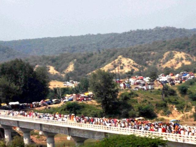 Pilgrims heading towards the Ratangarh temple through the Sindhu River bridge where a stamede took place, in Datia district of Madhya Pradesh on Sunday morning. (PTI Photo)