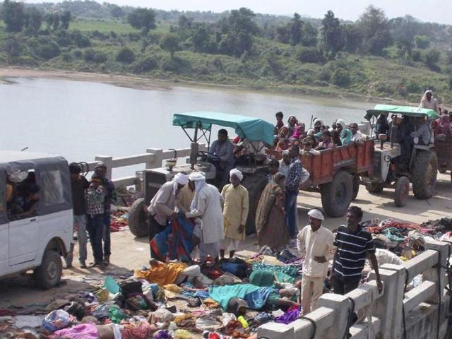Villagers on tractors move past bodies of victims of a stampede on a bridge across the Sindh River in Datia district in Madhya Pradesh state. (AP Photo)