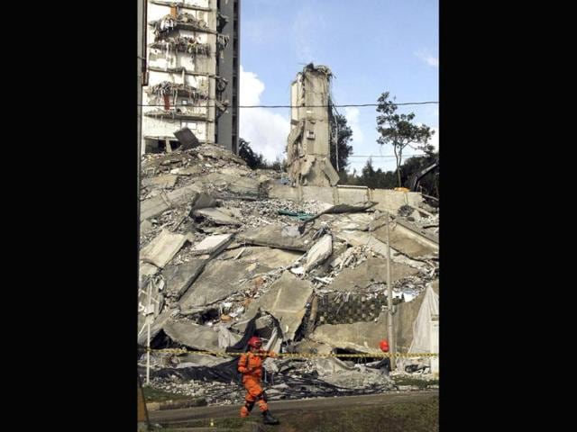 A rescuer walks past the rubble of an apartment building that collapsed in Medellin.(Reuters photo)