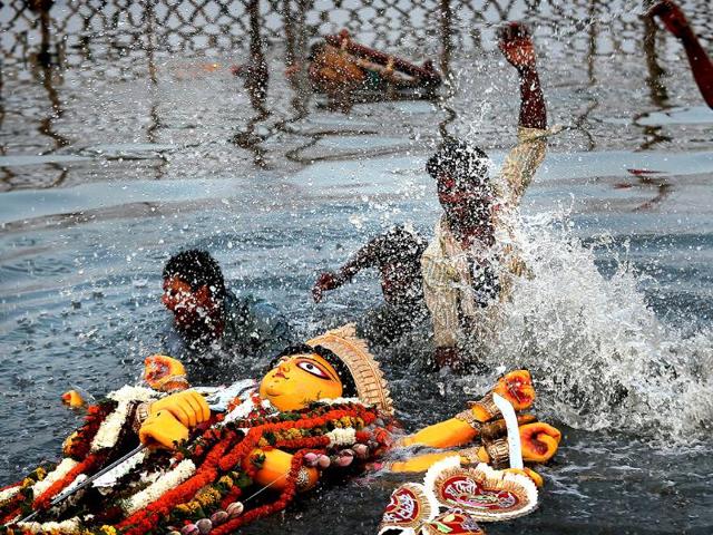 Hindu devotees immerse an idol of Hindu goddess Durga in the river Yamuna at the end of the Durga Puja festival, in New Delhi. AP Photo