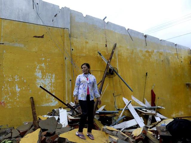 Nguyen Thi Linh stands among debris of her home, which collapsed due to Typhoon Nari, in Vietnam's central Quang Nam province. Reuters/Duc Hien
