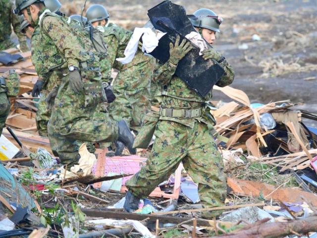Ground self-defense force rescue members search for survivors after a landslide caused by heavy rains of typhoon Wipha buried houses at Oshima island, Tokyo.(AFP photo)