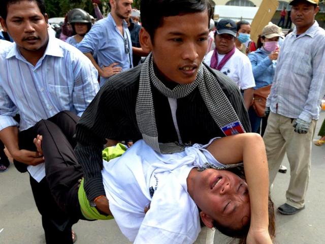 Cambodian land protesters carry a woman during a protest in Phnom Penh.(AFP photo)