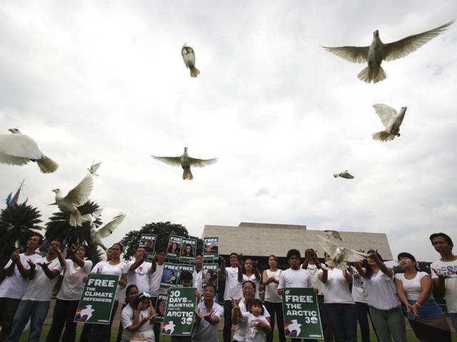 Filipino Greenpeace activists release white doves during a protest outside the Cultural Center of the Philippines in Manila, Philippines. (AP Photo)