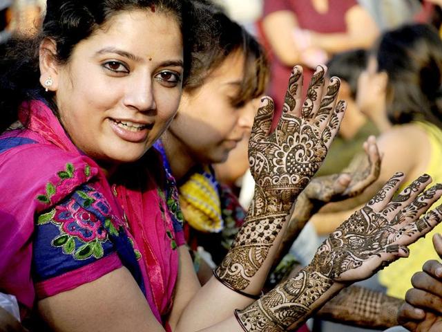 Women prepare mehendi designs on their hand for the Karva Chauth in Sadar Bazar in Gurgaon. (HT photo/Parveen Kumar)